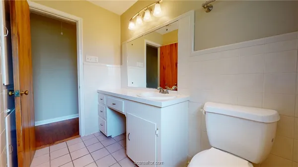 a bathroom with a toilet sink and mirror