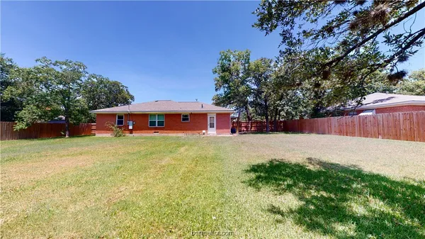 a yellow house with trees in front of it