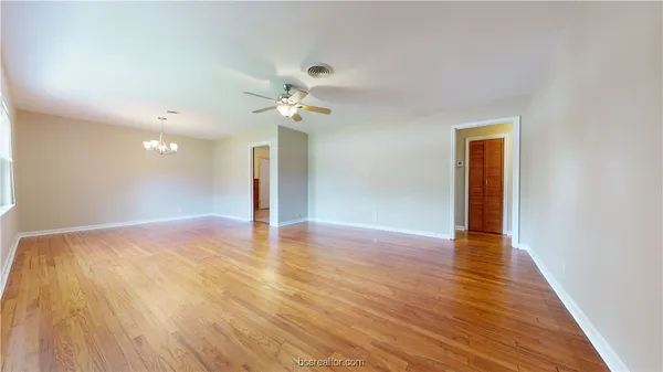 a view of an empty room with wooden floor