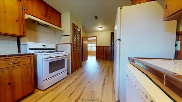 a kitchen with a stove top oven and cabinets