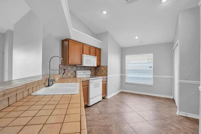 a large white kitchen with a sink a stove and a window