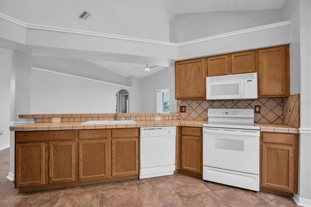 a kitchen with a stove sink and cabinets