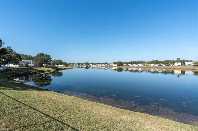 an aerial view of lake and residential houses with outdoor space