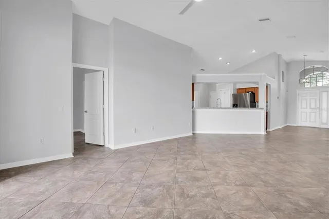 an empty room with kitchen and windows