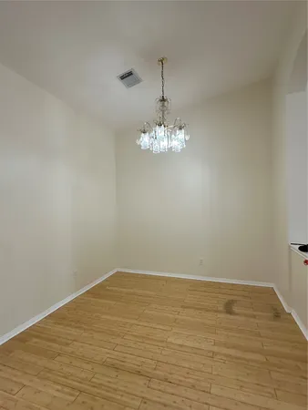 a view of a room with wooden floor and chandelier