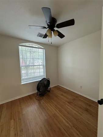 a living room with wooden floor and a window