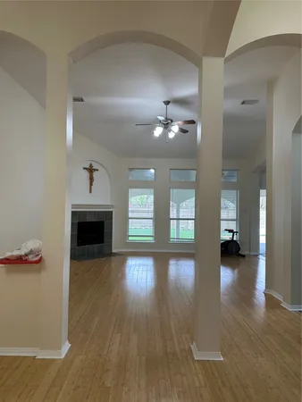 a view of a livingroom with wooden floor and a kitchen