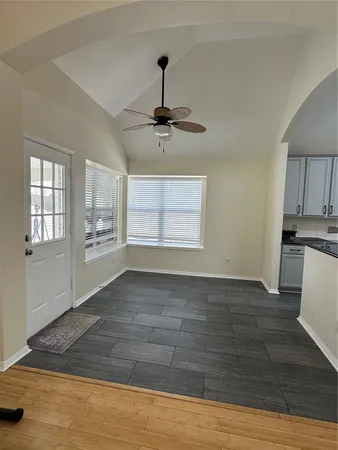 a view of an empty room with window and wooden floor