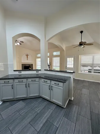 a large kitchen with stainless steel appliances granite countertop a lot of counter space and wooden floor