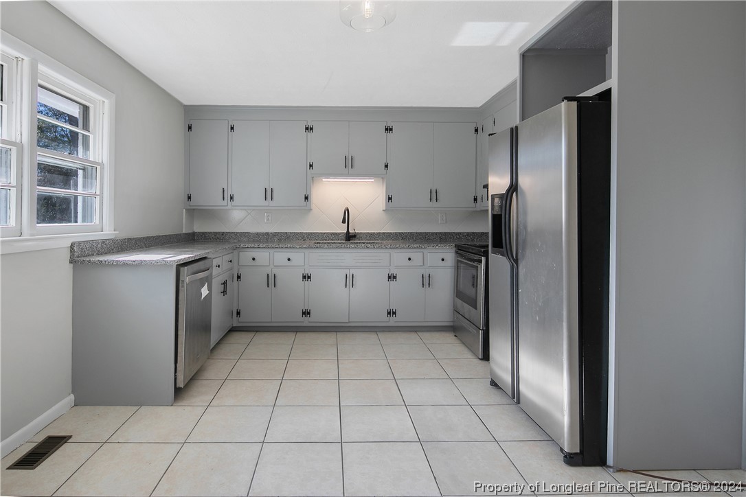 407 Ruth Street Spring Lake, NC 28390 - Photo 11 of 38 a kitchen with stainless steel appliances a refrigerator and cabinets