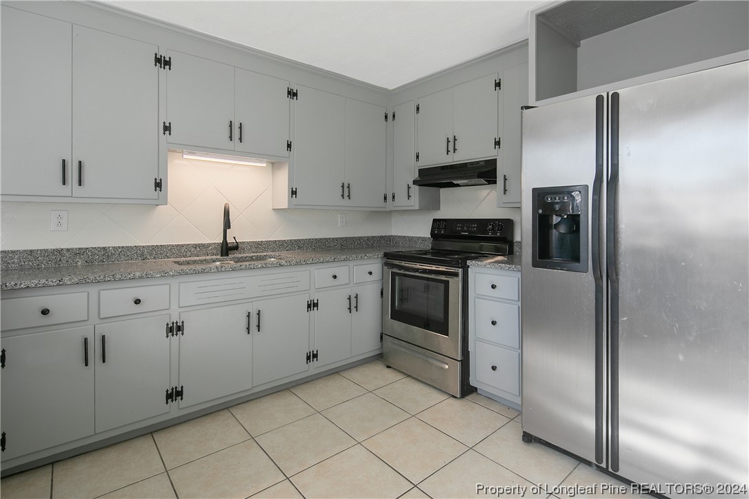 407 Ruth Street Spring Lake, NC 28390 - Photo 16 of 38 a kitchen with granite countertop white cabinets and stainless steel appliances