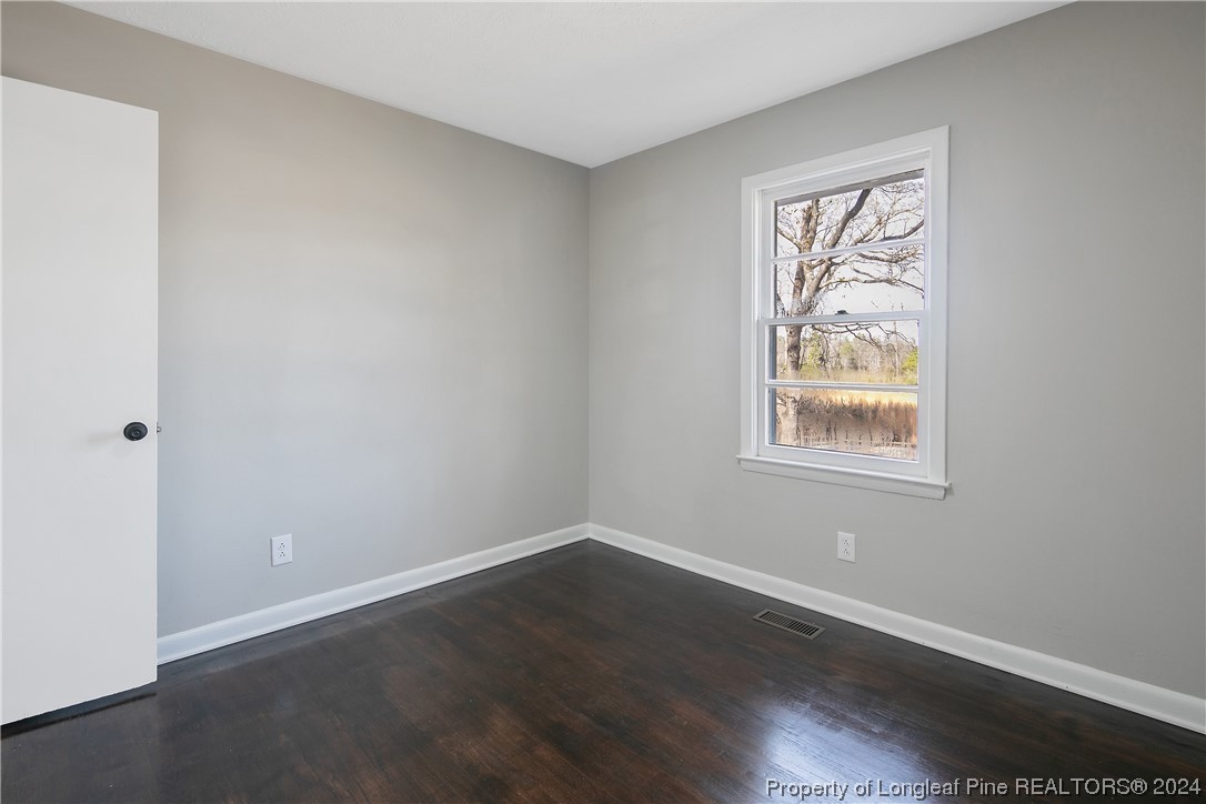 407 Ruth Street Spring Lake, NC 28390 - Photo 22 of 38 an empty room with wooden floor and windows