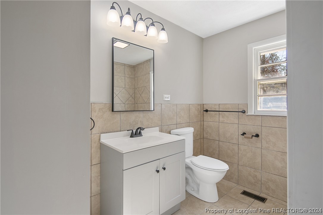 407 Ruth Street Spring Lake, NC 28390 - Photo 28 of 38 a bathroom with a toilet sink and mirror