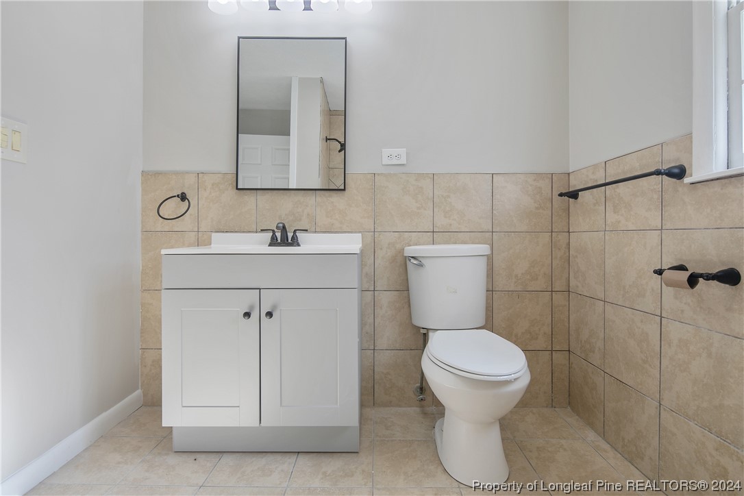 407 Ruth Street Spring Lake, NC 28390 - Photo 29 of 38 a bathroom with a toilet sink and mirror