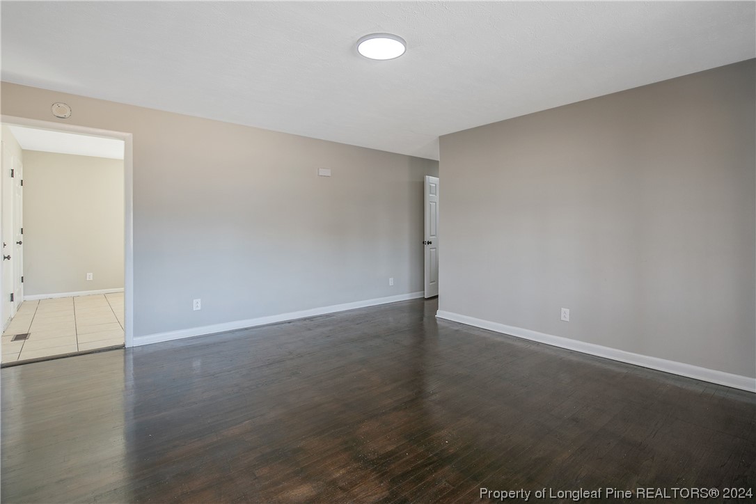 407 Ruth Street Spring Lake, NC 28390 - Photo 7 of 38 an empty room with wooden floor and windows