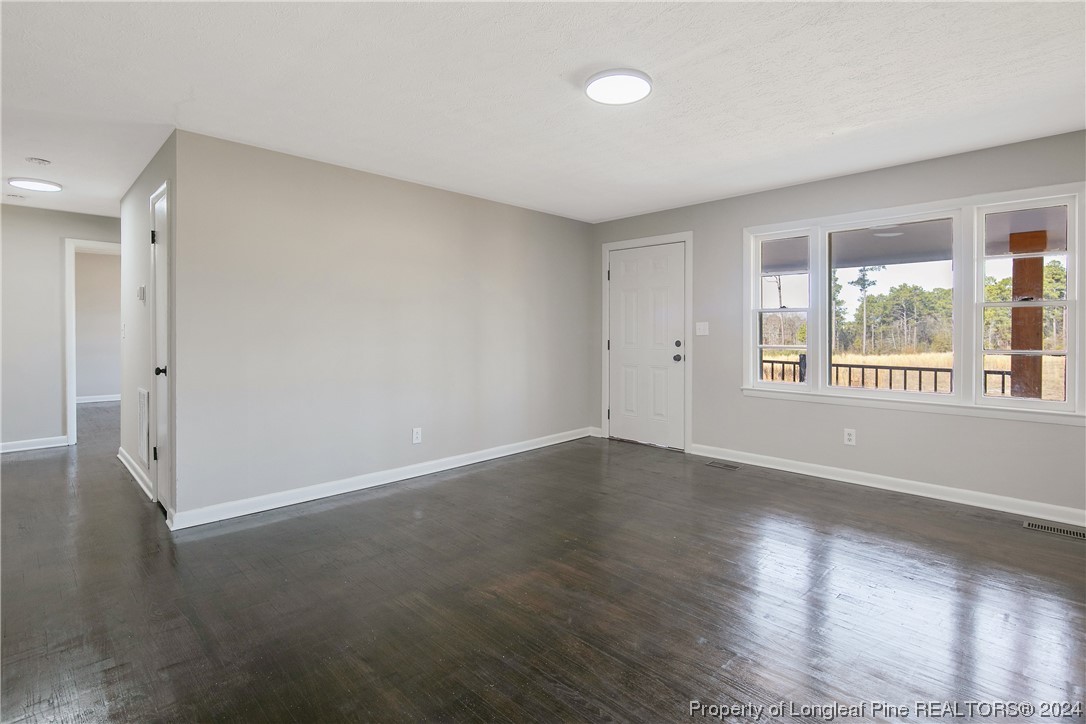 407 Ruth Street Spring Lake, NC 28390 - Photo 8 of 38 an empty room with wooden floor and windows