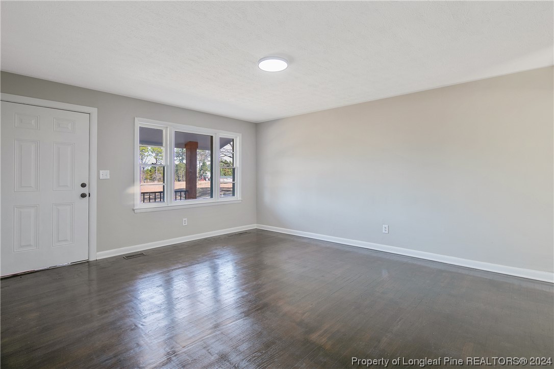 407 Ruth Street Spring Lake, NC 28390 - Photo 9 of 38 a view of an empty room with wooden floor and a window