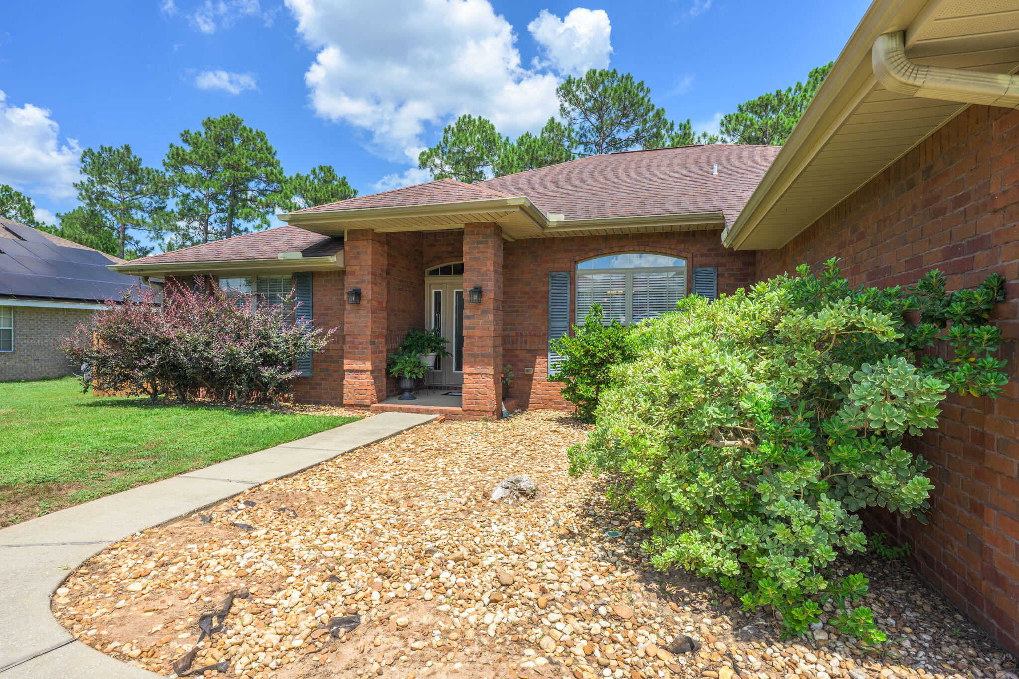 222 Raptor Drive Crestview, FL 32536 - Photo 9 of 70 a view of a house with brick walls plants and large tree