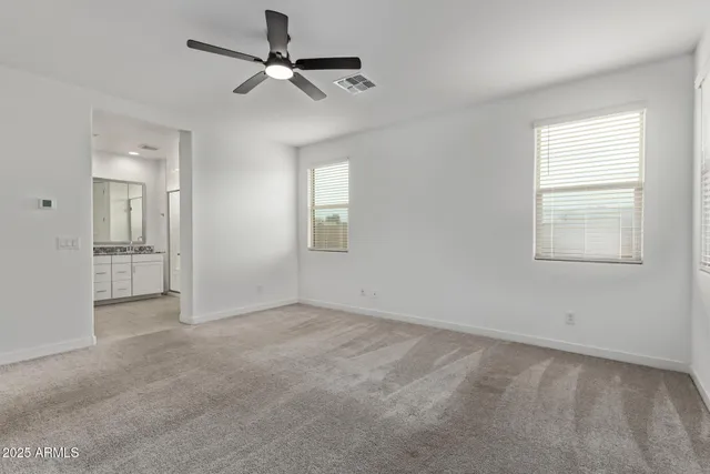 an empty room with fan and windows