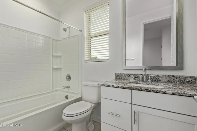 a bathroom with a granite countertop toilet a sink and a bathtub