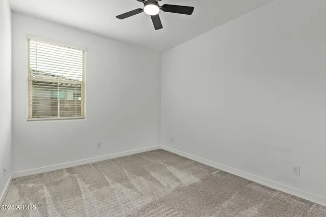 an empty room with a window with a fan