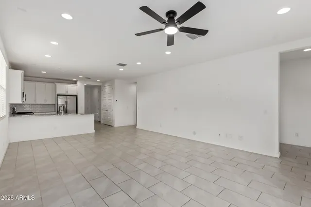 a view of an empty room and kitchen view