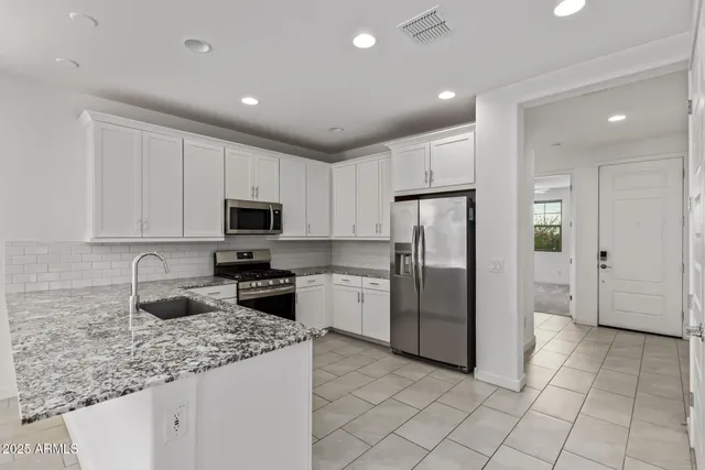 a kitchen with stainless steel appliances granite countertop a refrigerator sink and cabinets