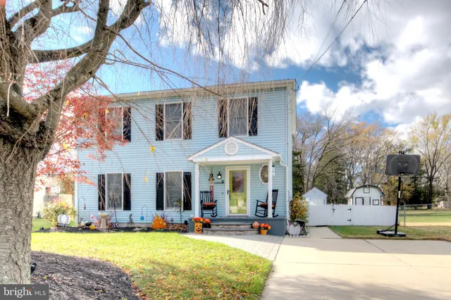 a front view of a house with a yard and trees