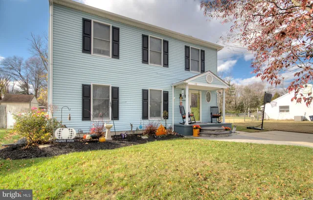 a house view with swimming pool in front of residential house with trees