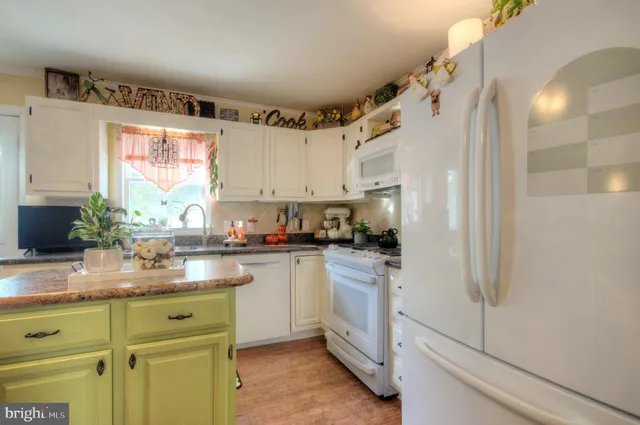 a kitchen with kitchen island granite countertop a sink a counter top space and cabinets