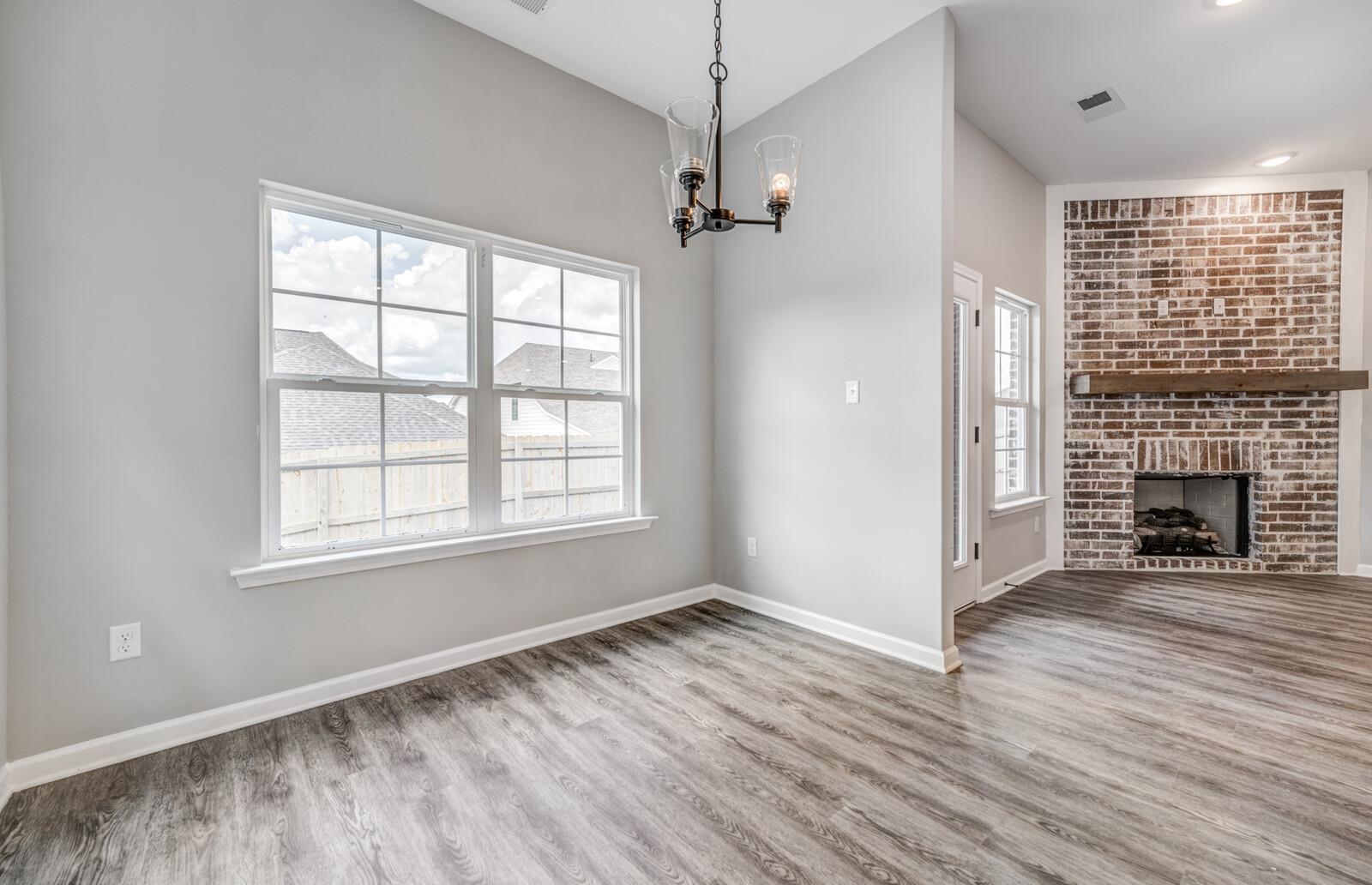 100 Blue Street Oakland, TN 38060 - Photo 11 of 40 an empty room with wooden floor fireplace and windows