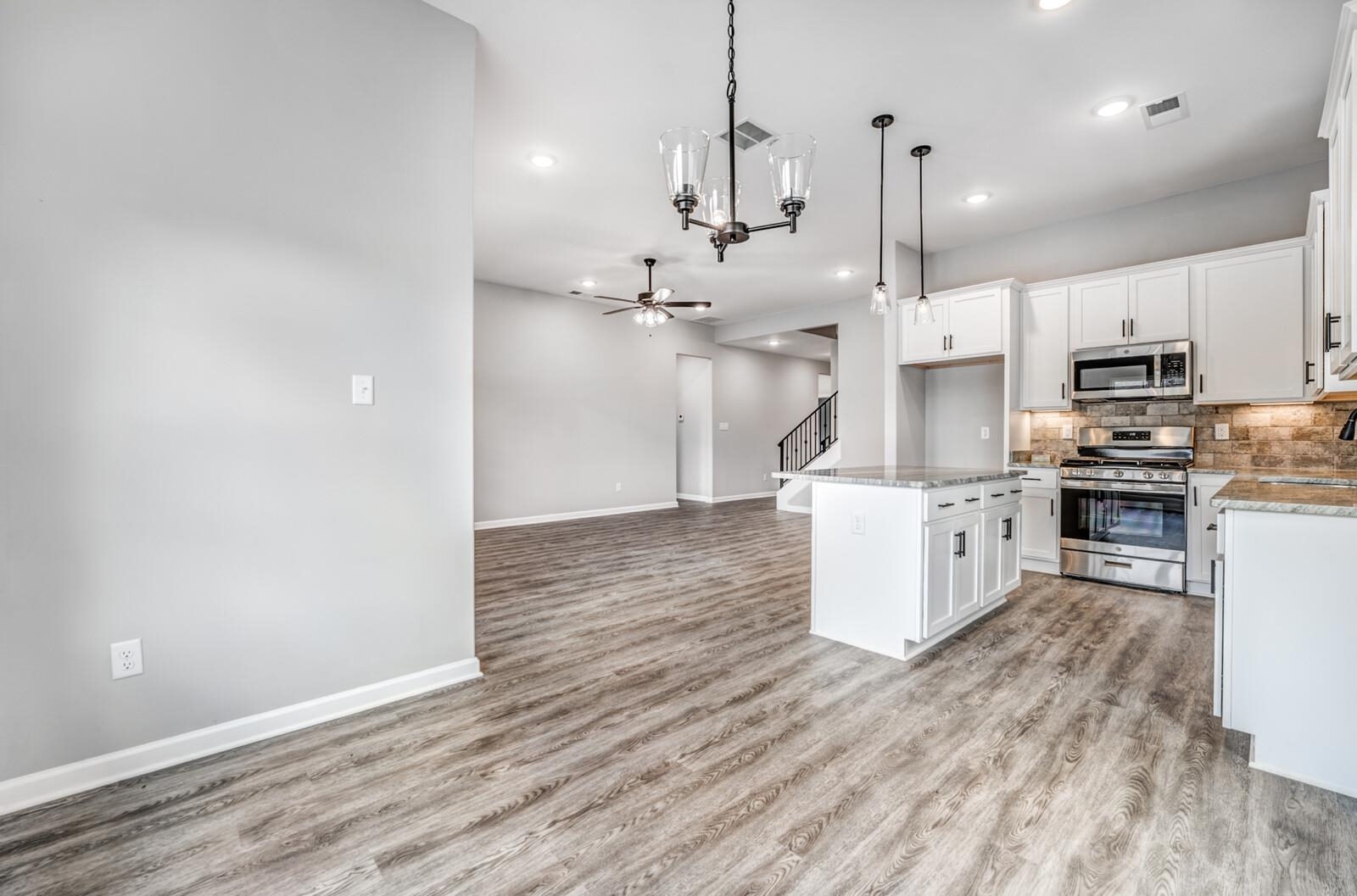 100 Blue Street Oakland, TN 38060 - Photo 12 of 40 a large kitchen with cabinets wooden floor and stainless steel appliances