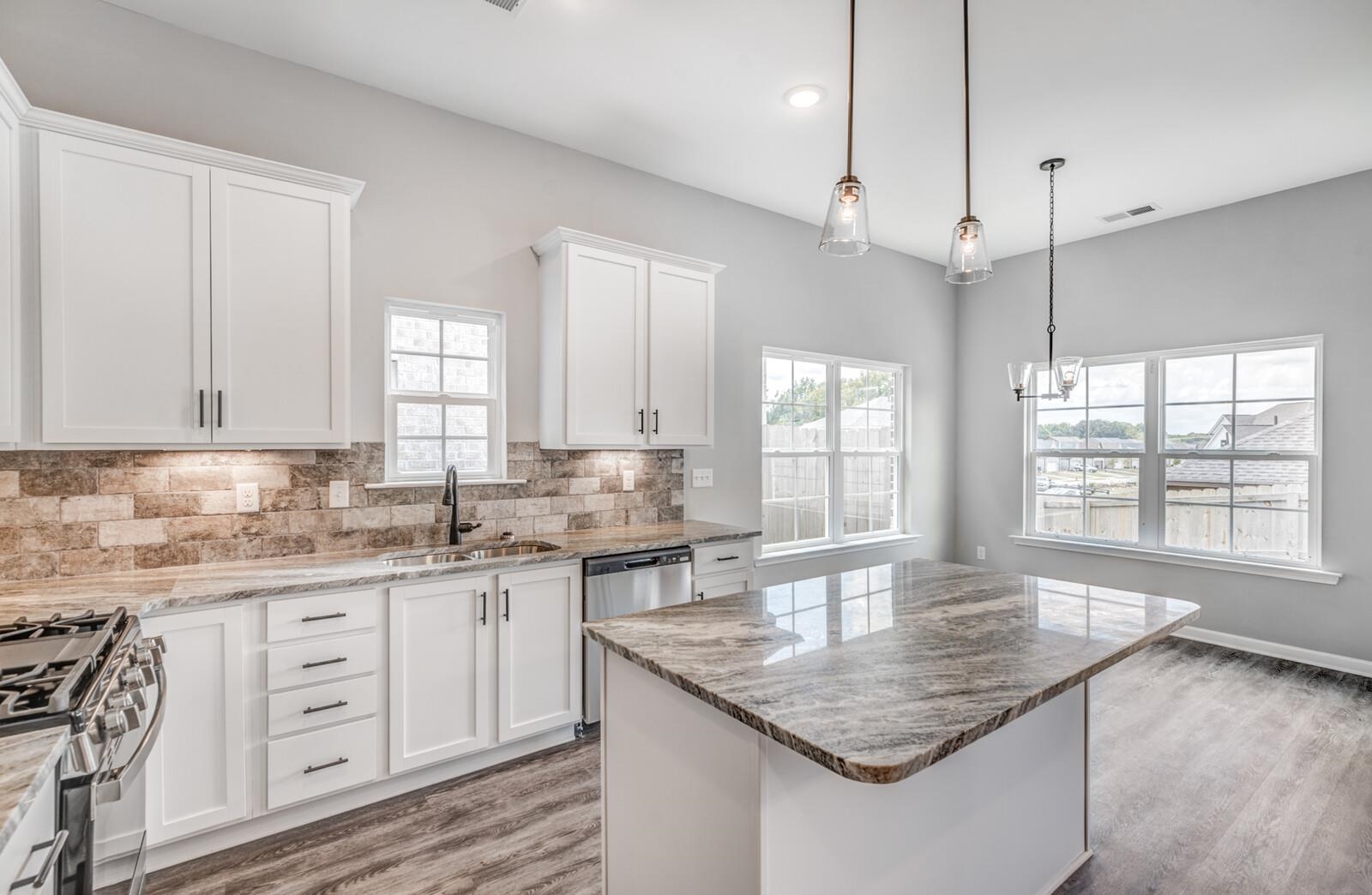 100 Blue Street Oakland, TN 38060 - Photo 14 of 40 a kitchen with granite countertop a sink a center island and windows