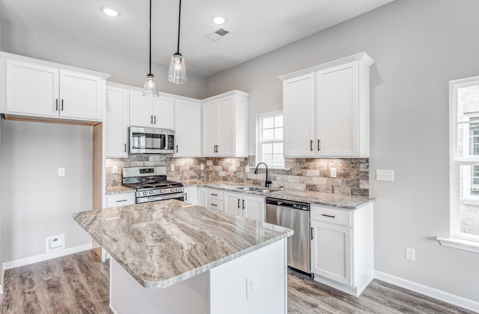 100 Blue Street Oakland, TN 38060 - Photo 15 of 40 a kitchen with stainless steel appliances granite countertop a sink stove and refrigerator