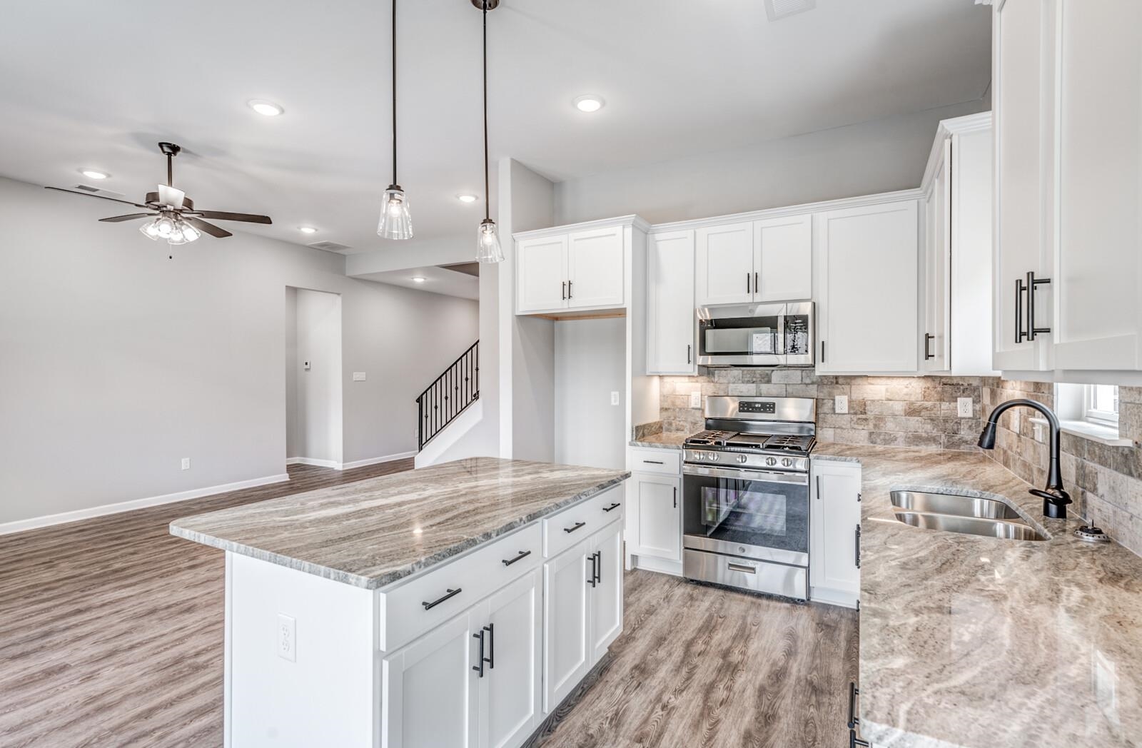 100 Blue Street Oakland, TN 38060 - Photo 16 of 40 a kitchen with stainless steel appliances granite countertop a stove a sink a refrigerator and a microwave