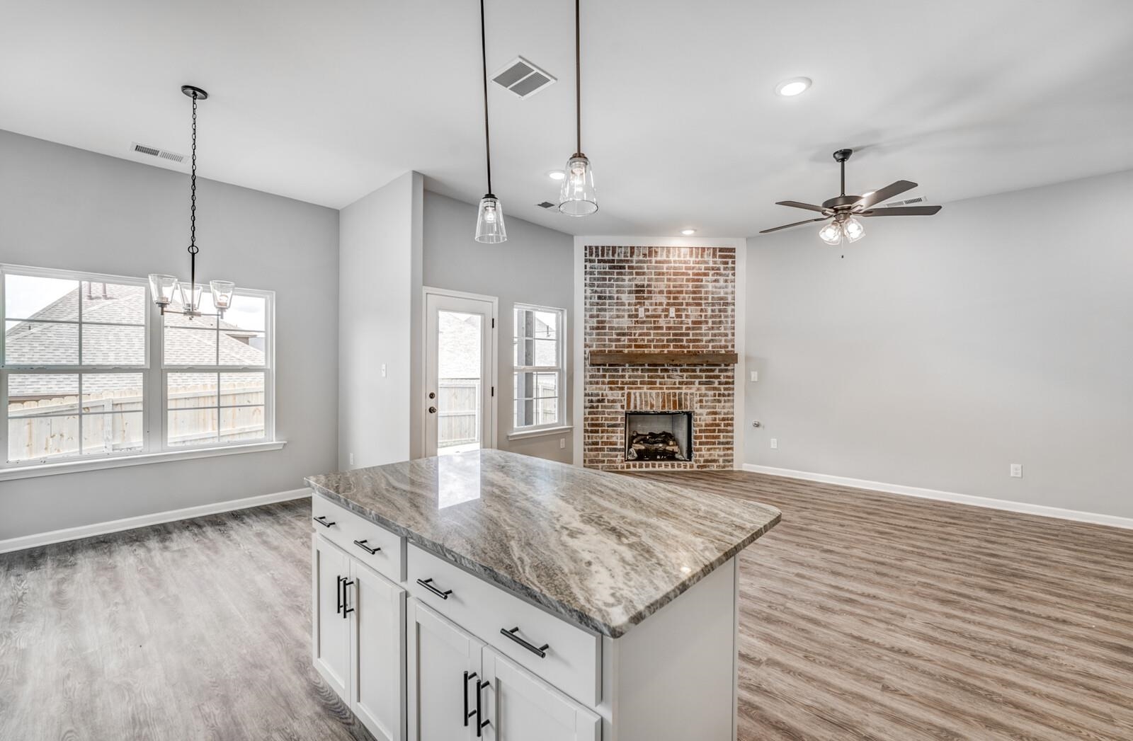 100 Blue Street Oakland, TN 38060 - Photo 17 of 40 a kitchen with granite countertop a stove a sink and a chandelier