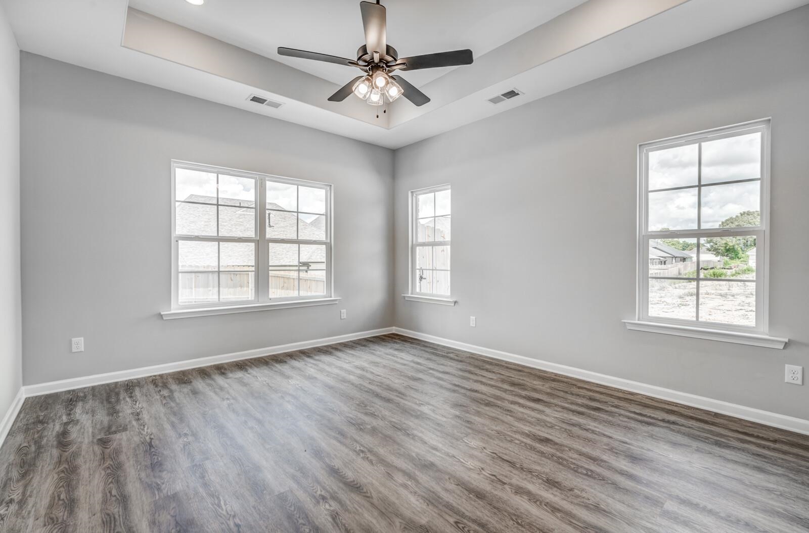 100 Blue Street Oakland, TN 38060 - Photo 19 of 40 an empty room with wooden floor ceiling fan and windows