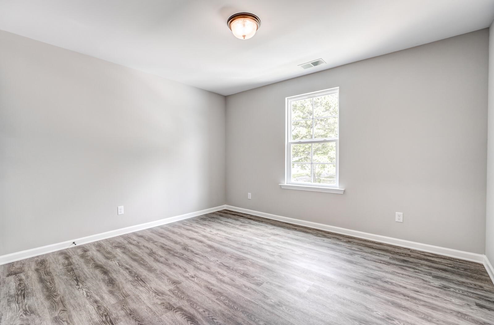 100 Blue Street Oakland, TN 38060 - Photo 29 of 40 an empty room with wooden floor and windows