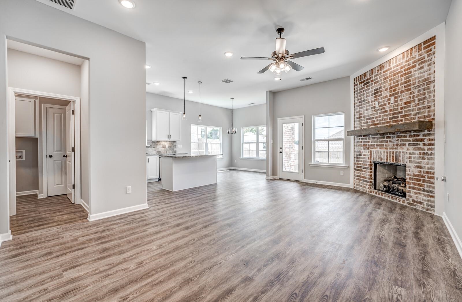 100 Blue Street Oakland, TN 38060 - Photo 6 of 40 an empty room with wooden floor fireplace and windows