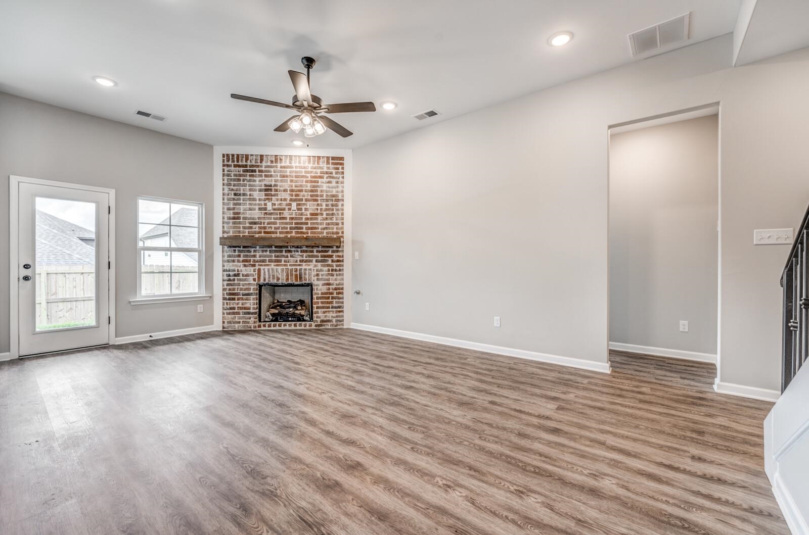100 Blue Street Oakland, TN 38060 - Photo 7 of 40 an empty room with wooden floor fireplace and windows