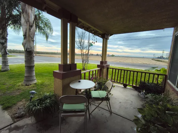 a porch with a bench next to a yard