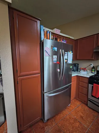a metallic refrigerator freezer sitting in a kitchen