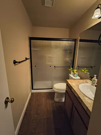 a bathroom with a sink a toilet a mirror and shower