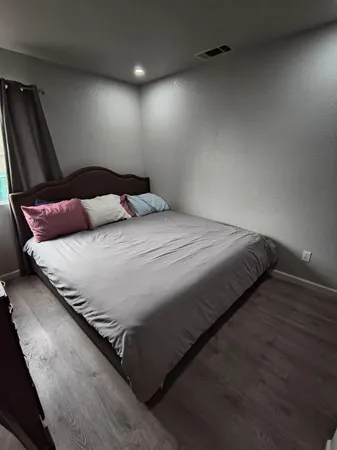 a bedroom with a bed and wooden floor