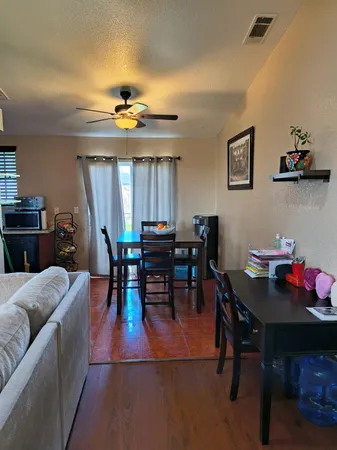a living room with furniture a chandelier and a dining table