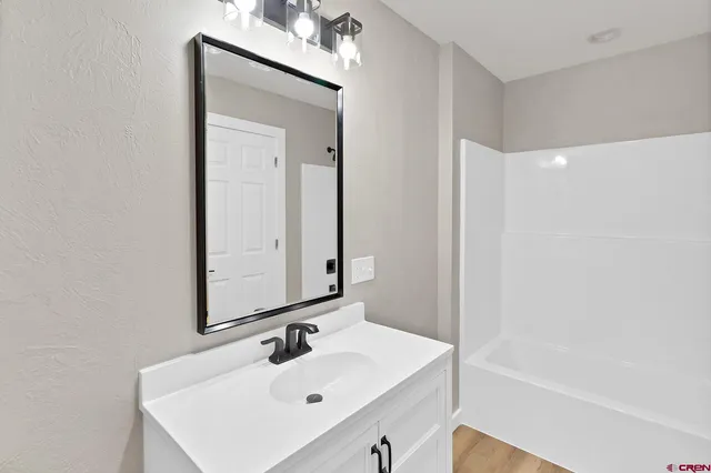 a bathroom with a sink a shower and a mirror