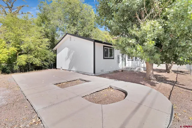 a backyard of a house with table and chairs