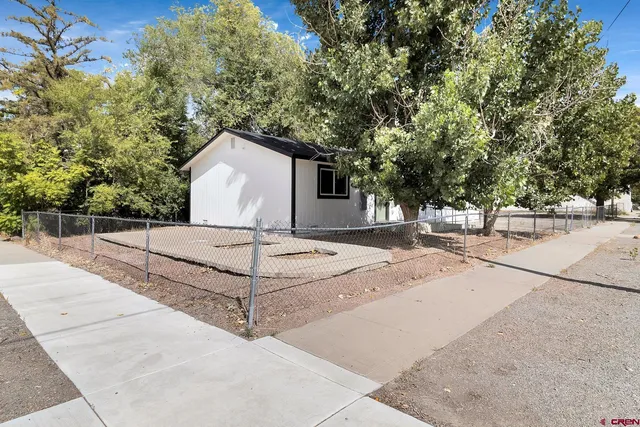 a white house that has a tree in front of it