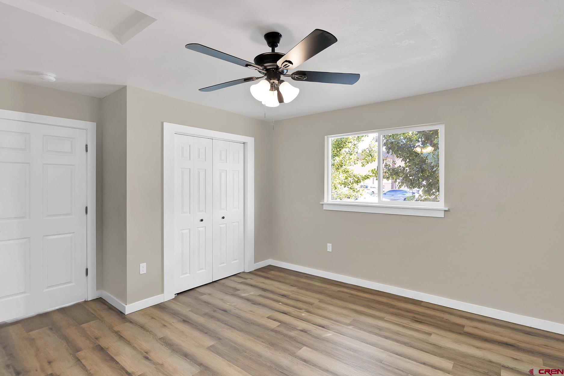 295 West 7th Street Delta, CO 81416 - Photo 7 of 34 a view of an empty room with wooden floor and a ceiling fan