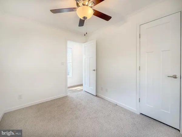 an empty room with a ceiling fan and a window